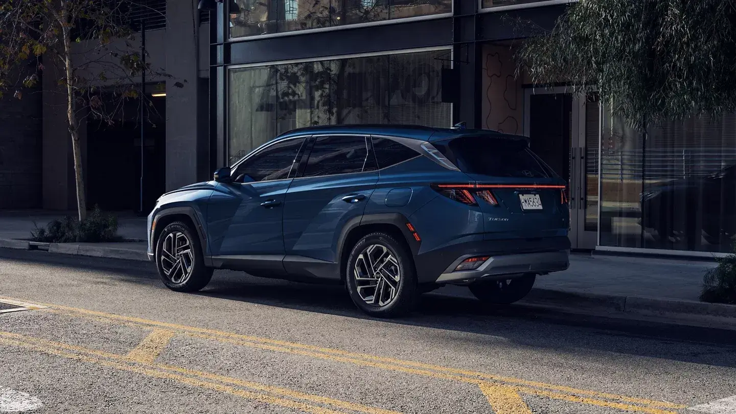 Blue 2026 Hyundai Tucson parked on a city street, rear three-quarter view