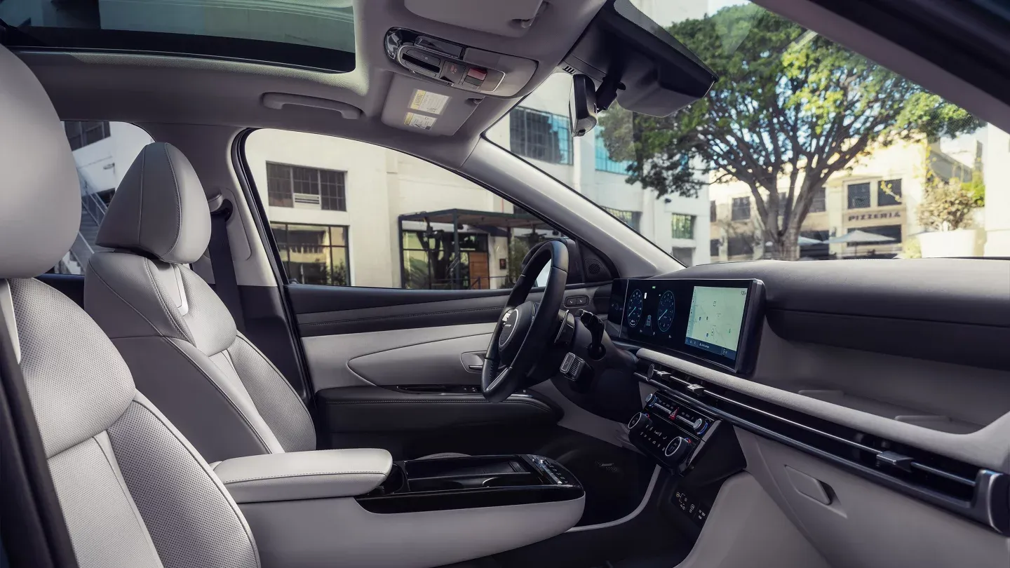2026 Hyundai Tucson gray front seats and dashboard seen through the open passenger door
