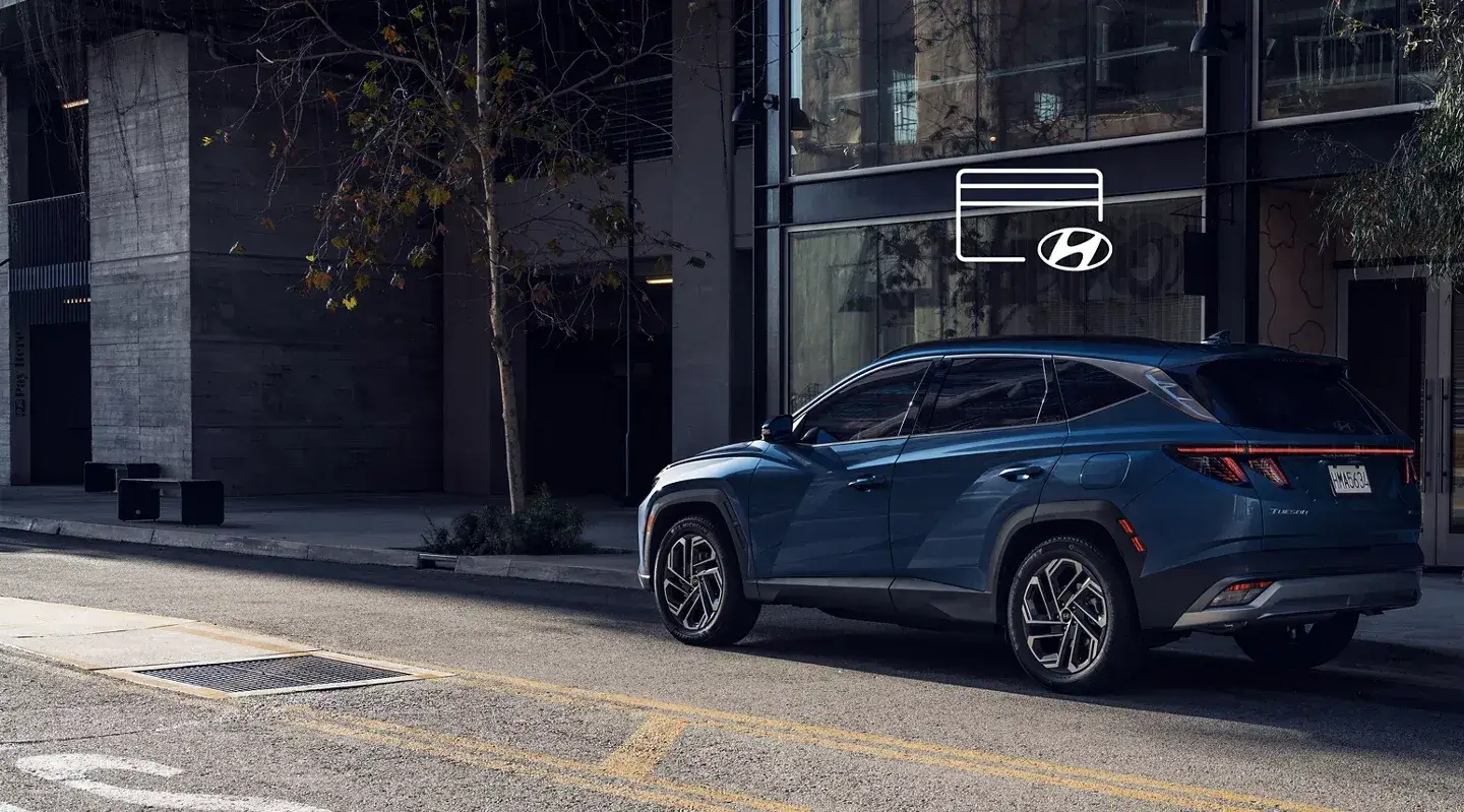 Blue 2026 Hyundai Tucson parked on a city street, rear three-quarter view