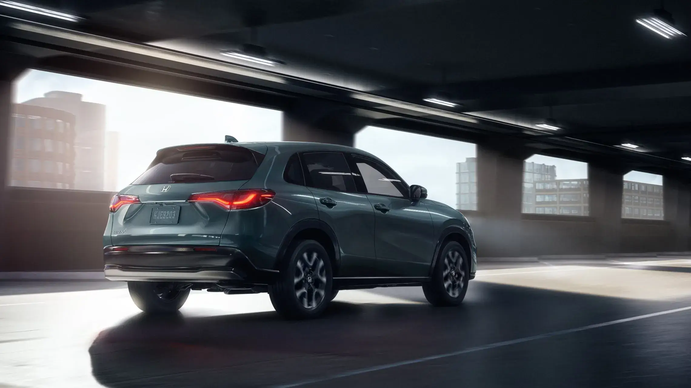 2027 Honda HR-V rear three-quarter view leaving a sunlit parking garage