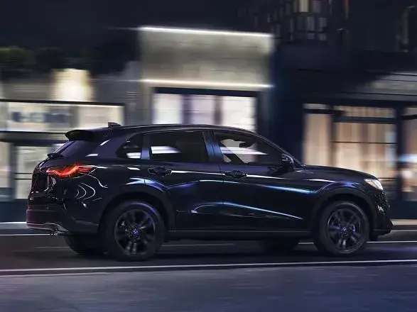 2027 Honda HR-V Sport in Crystal Black Pearl, side view on a city street at night