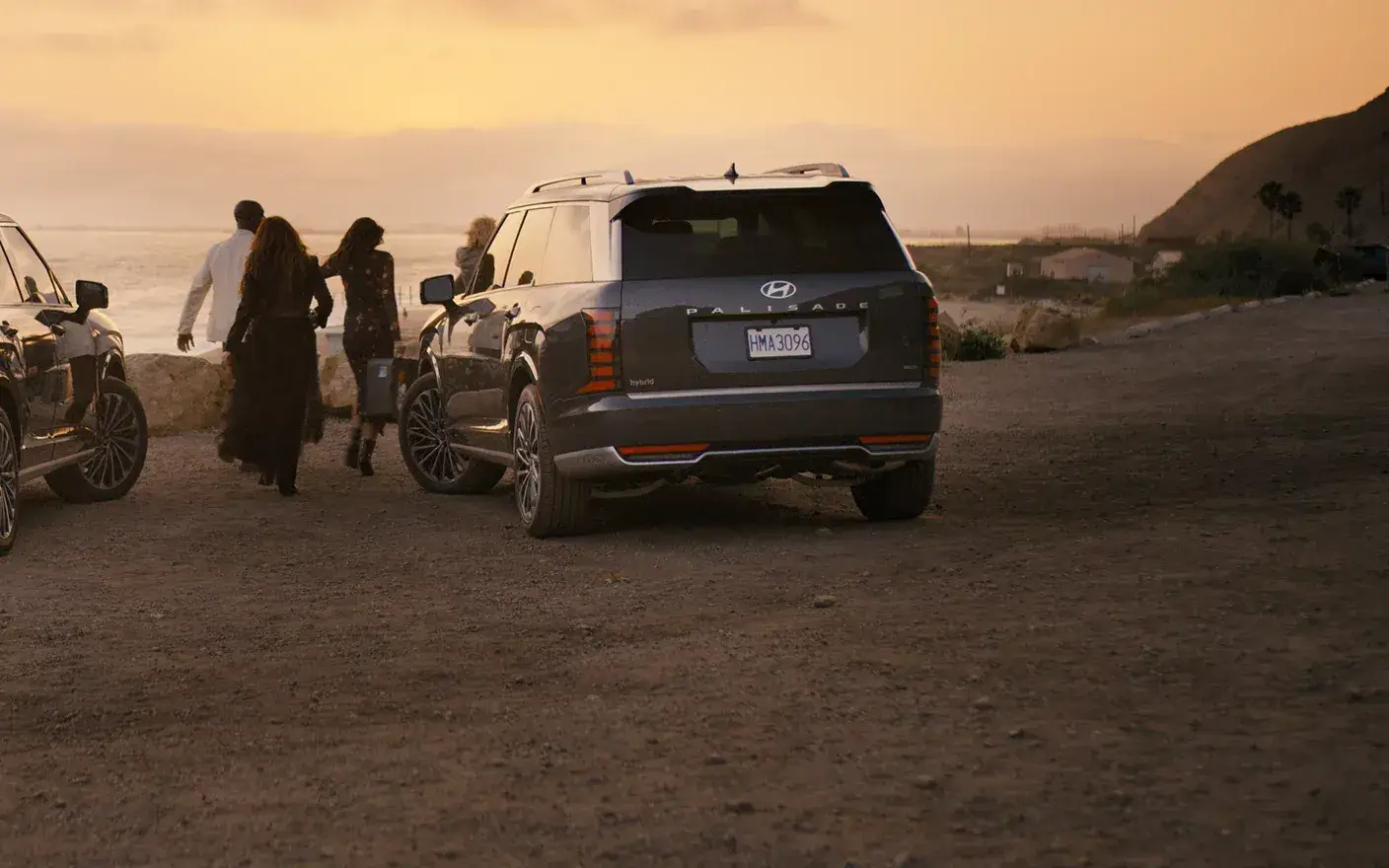 Dark 2027 Hyundai Palisade parked at a desert overlook at sunset, rear three-quarter view