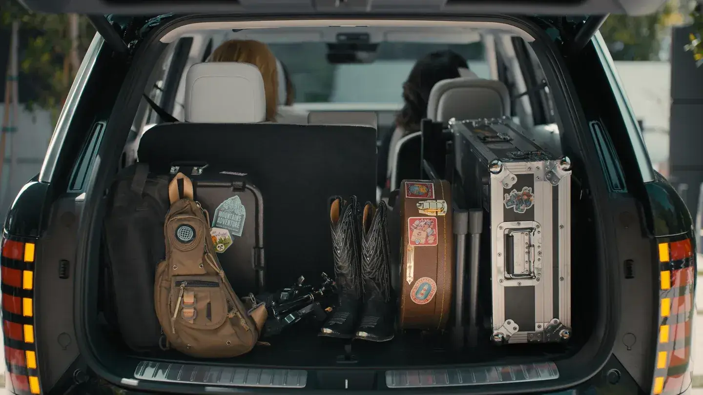 2027 Hyundai Palisade cargo area behind the third row loaded with a guitar and luggage