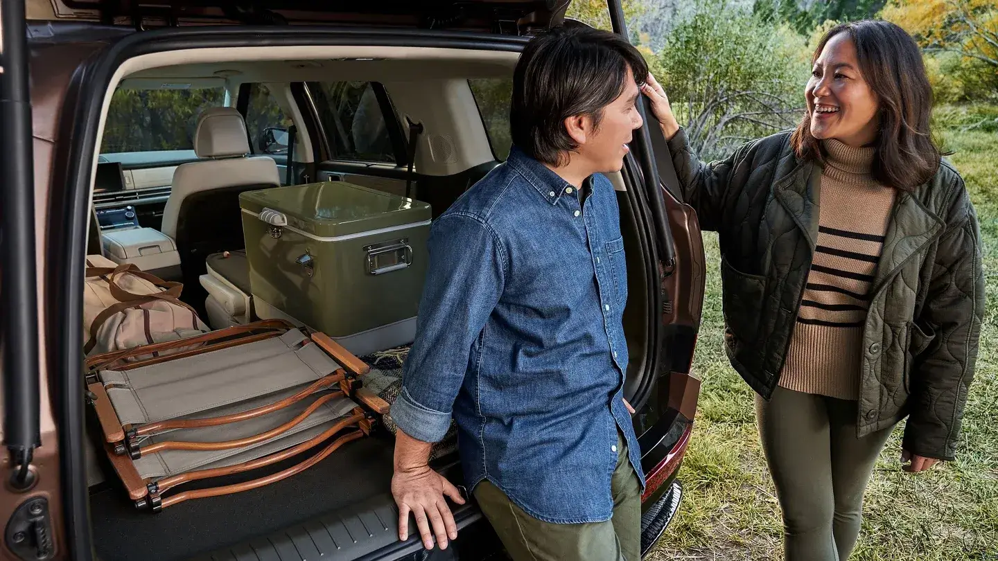 Couple at the open liftgate of a Hyundai Santa Fe with gear in the cargo area