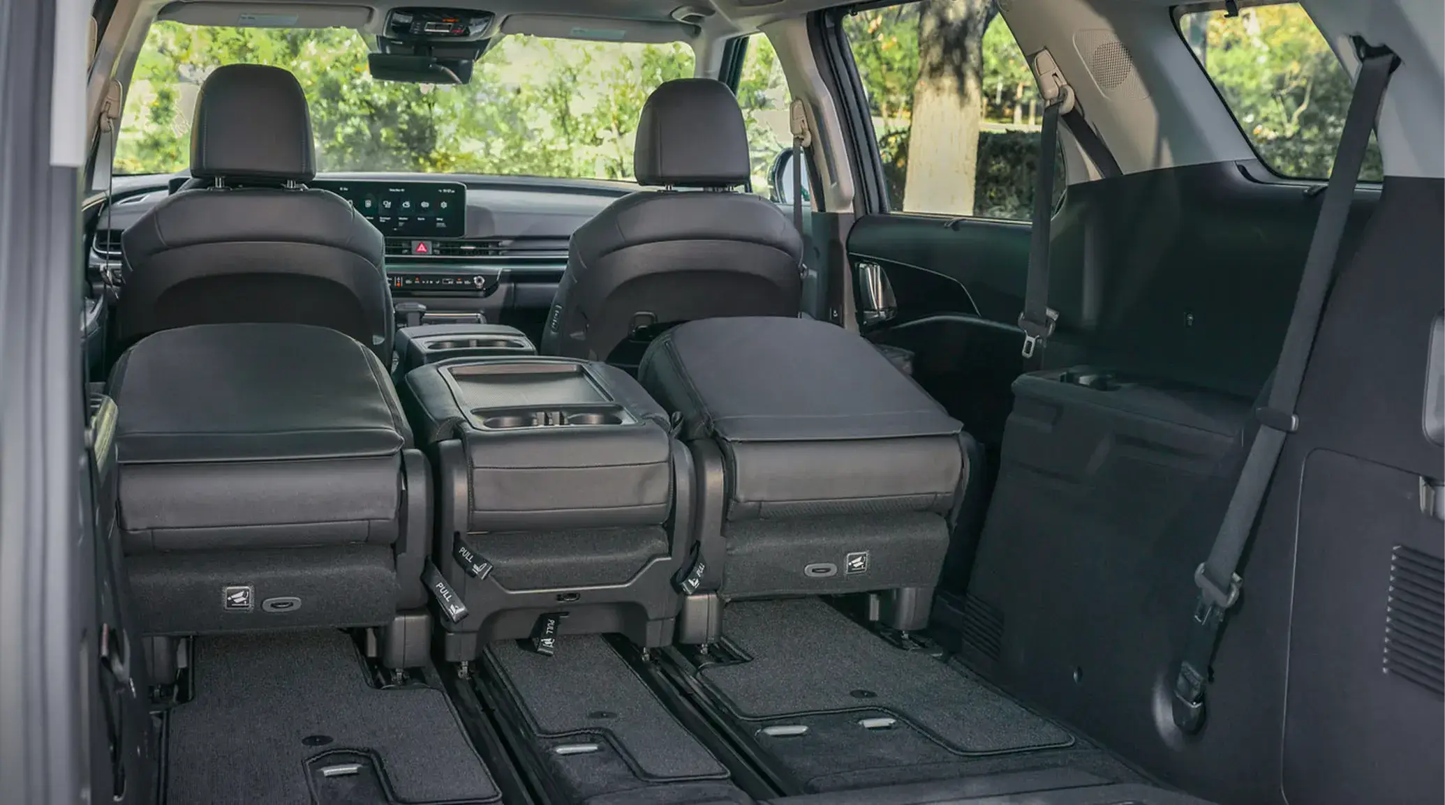 2027 Kia Carnival cabin seen from the cargo area with the third row folded flat