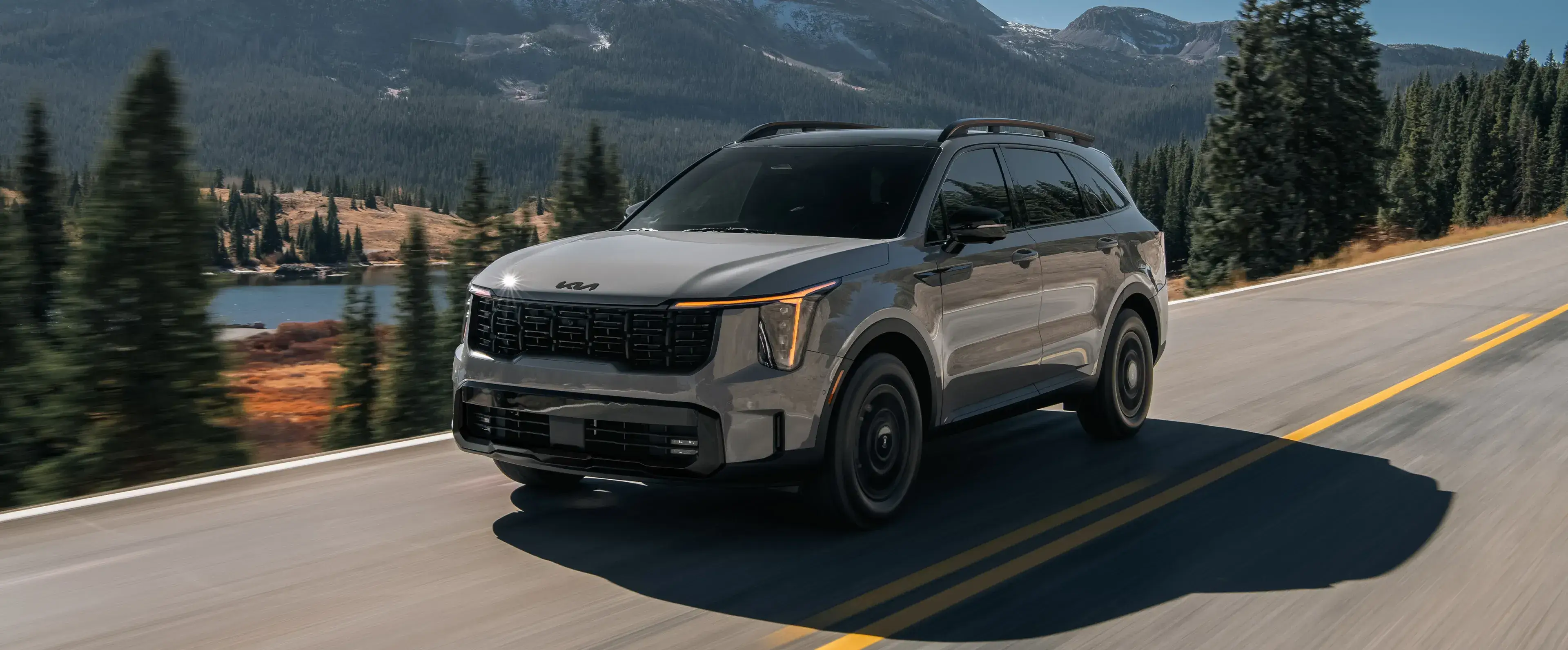 Gray Kia Sorento X-Line driving on a mountain road, front three-quarter view