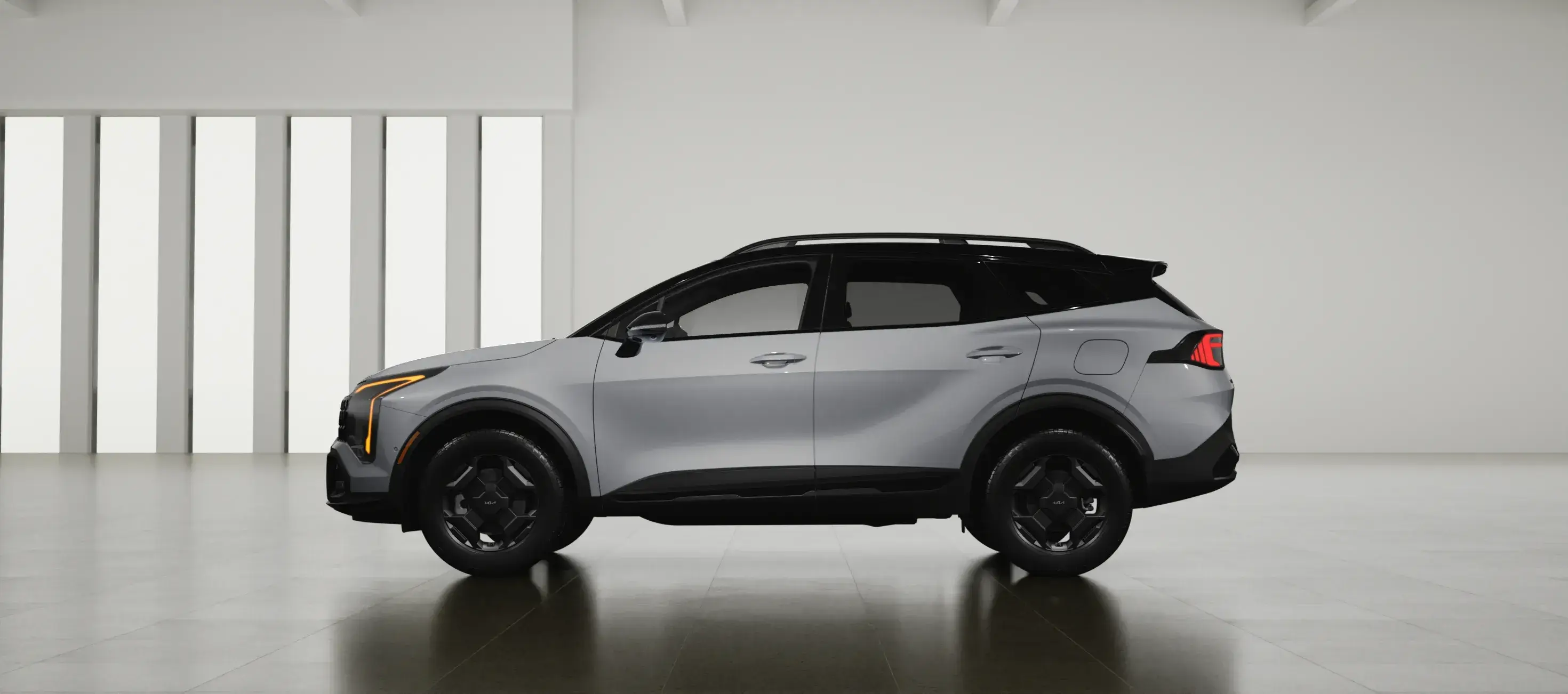 Silver 2027 Kia Sportage facing left in a white studio, side view