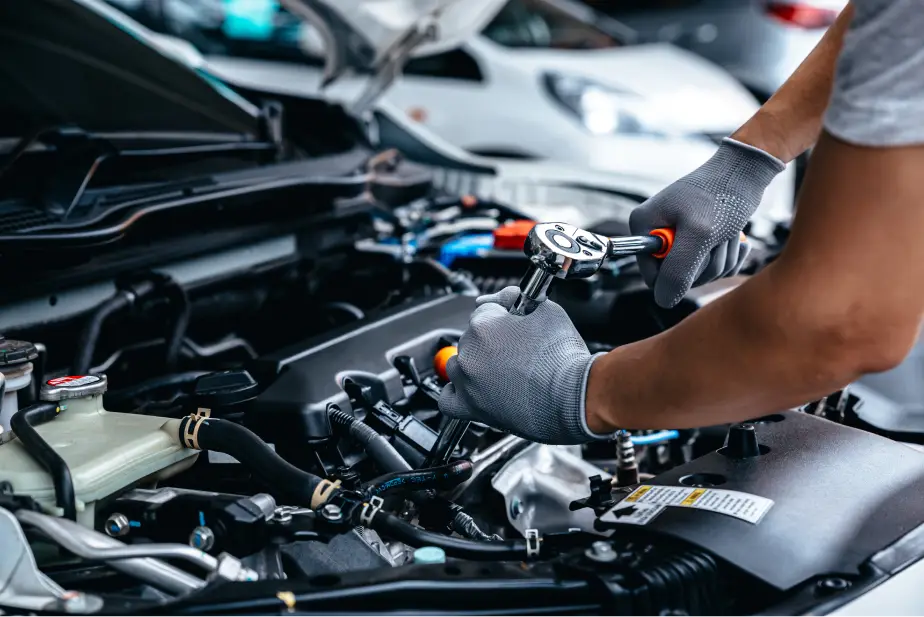 Technician working on a vehicle engine at Plaza Auto Mall service center