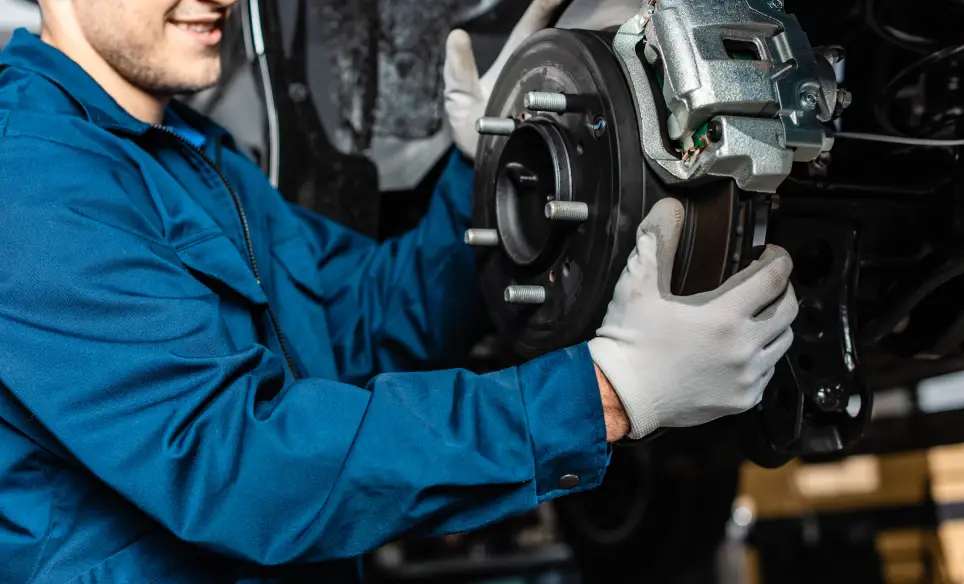 Technician performing brake service at Plaza Auto Mall service center