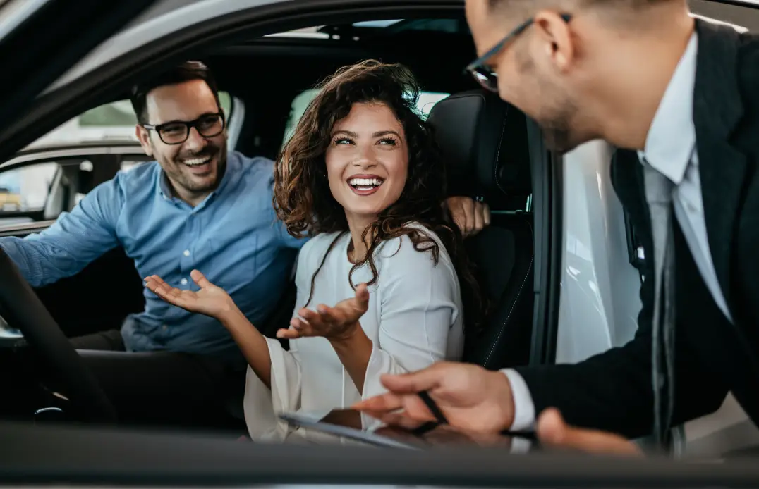 Customers speaking with a dealership representative while shopping for a vehicle at Plaza Auto Mall