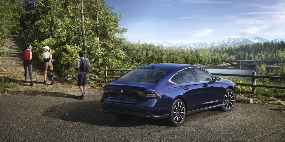 Blue Honda Accord parked by a lake, rear three-quarter view