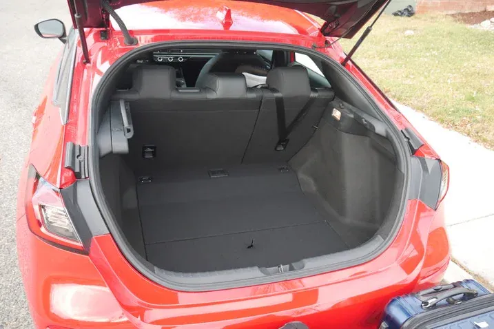 Red Honda Civic Hatchback with the liftgate open, showing the cargo area