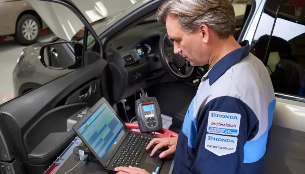 Honda technician performing diagnostics on a vehicle at a service center