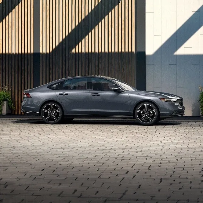Gray Honda Accord parked by a modern building, side profile
