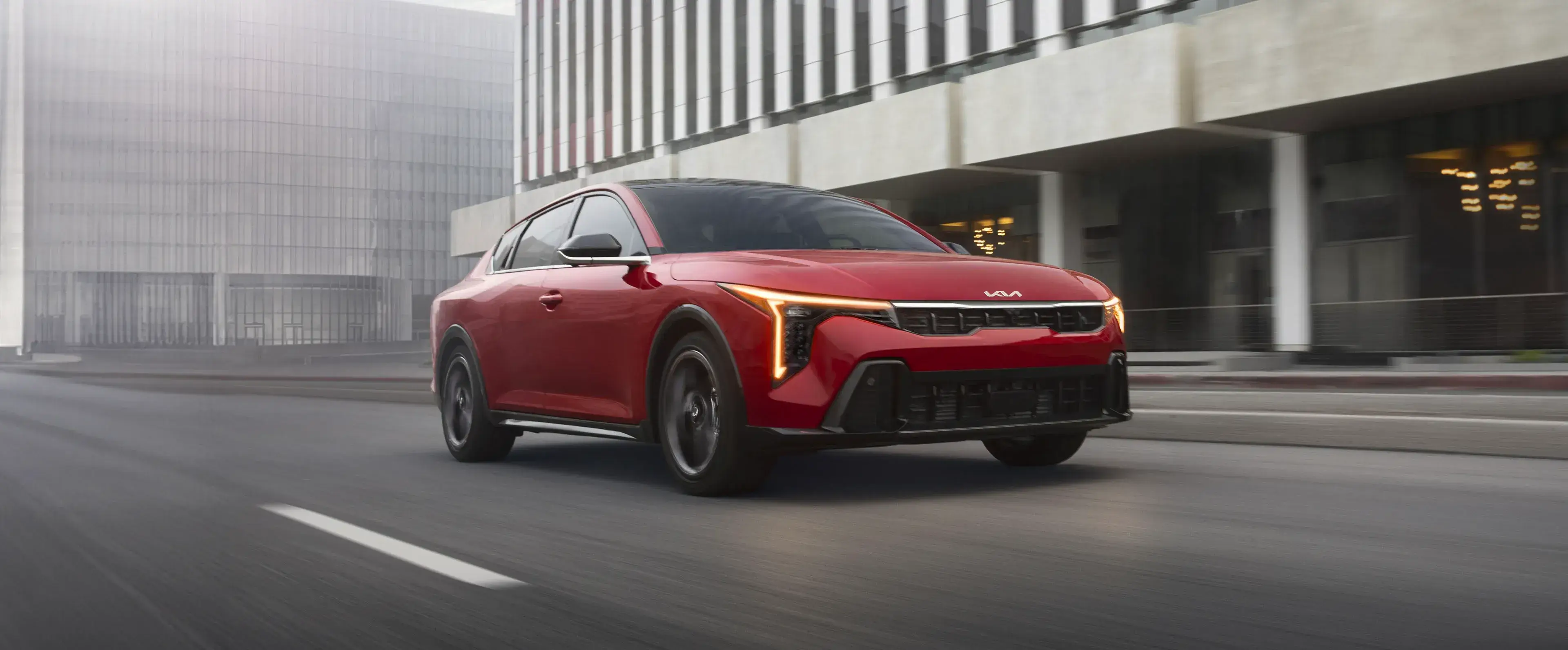 2027 Kia K4 with angular LED headlights and fastback profile on a city street