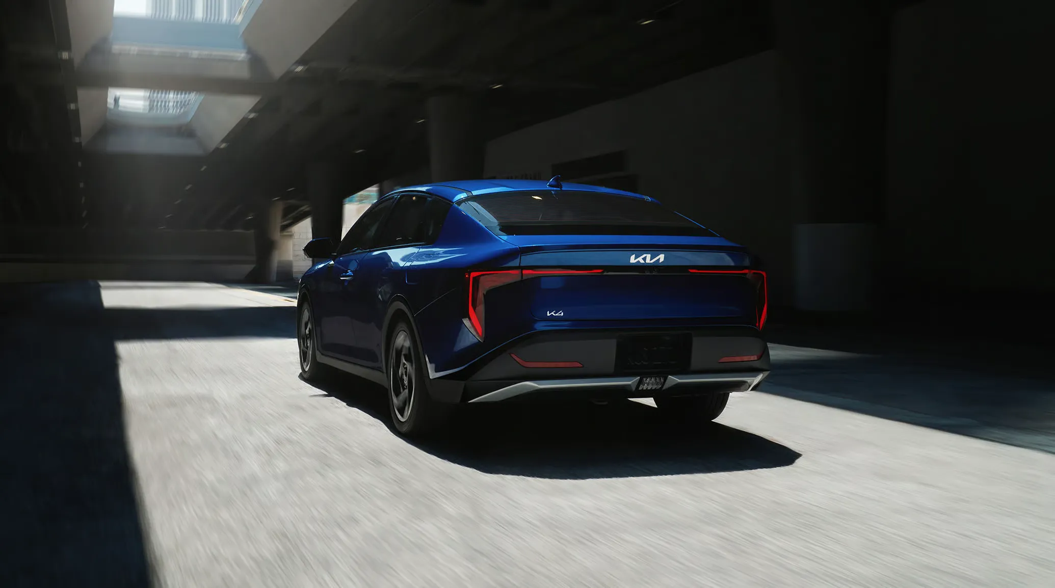 Rear view of the 2027 Kia K4 sedan showing its full-width taillight bar and fastback trunk