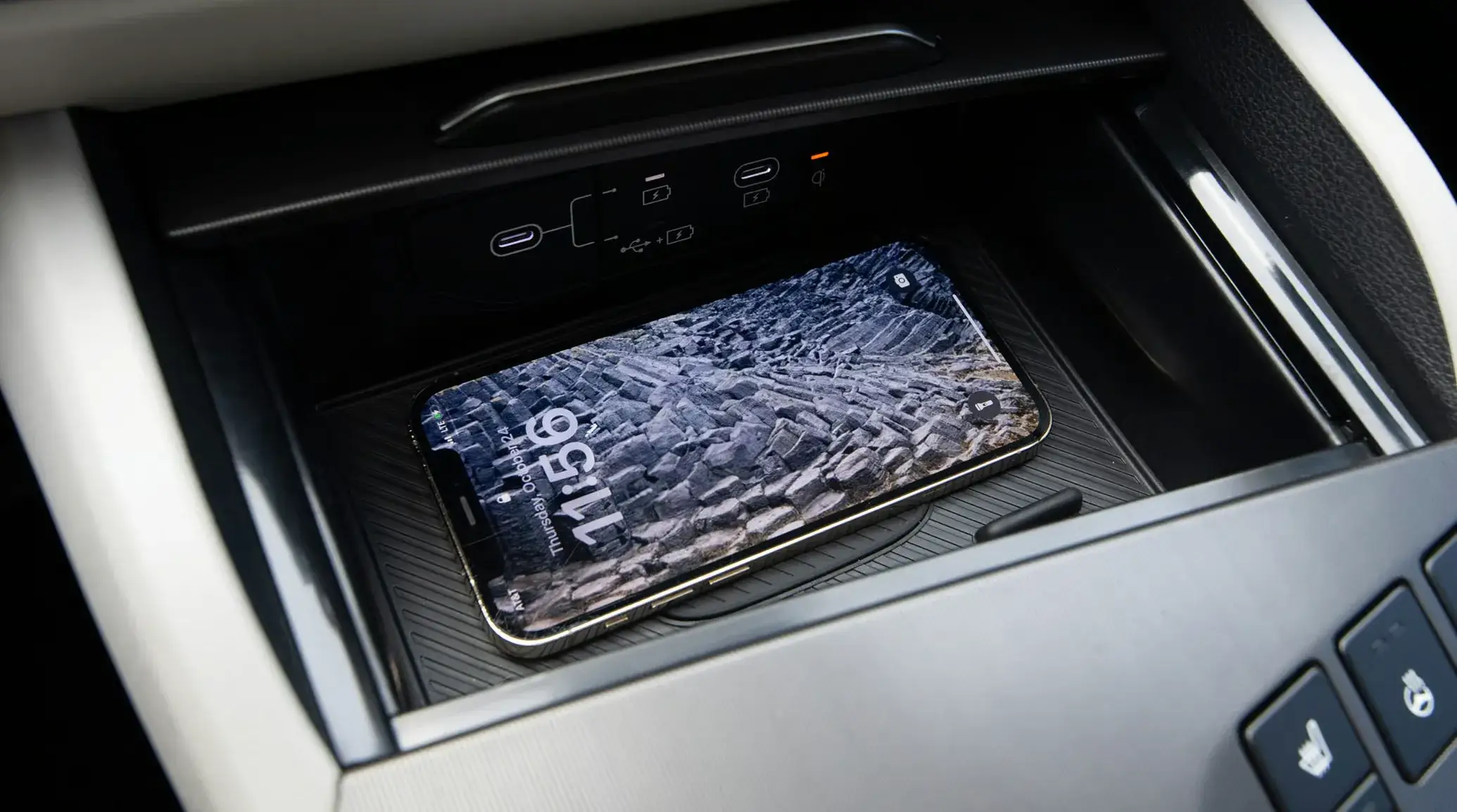 Wireless phone charging pad in the center console of the 2027 Kia Sportage Hybrid