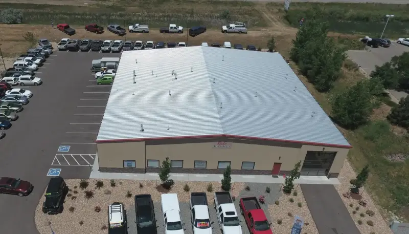 Aerial view of the Red’s Auto & Truck dealership building and vehicle lot in Longmont, Colorado.