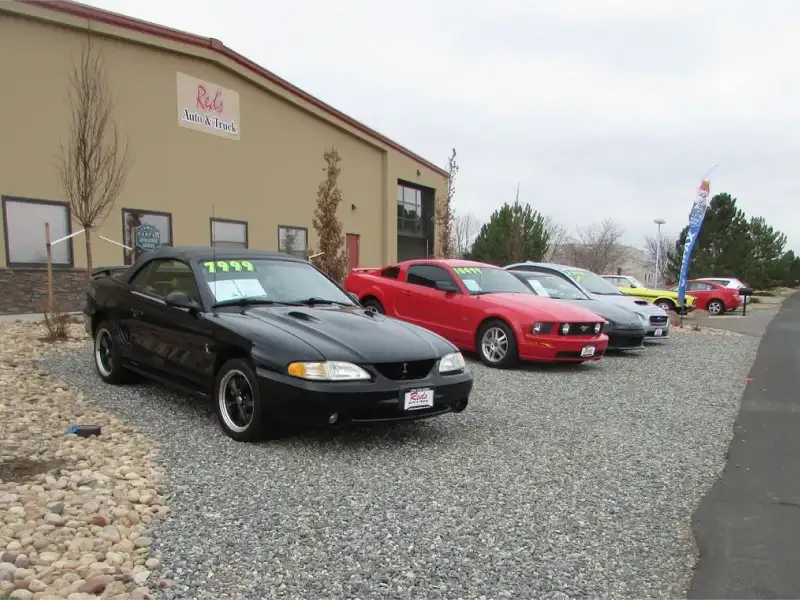 Used cars displayed outside the Red’s Auto & Truck dealership building in Longmont, Colorado.