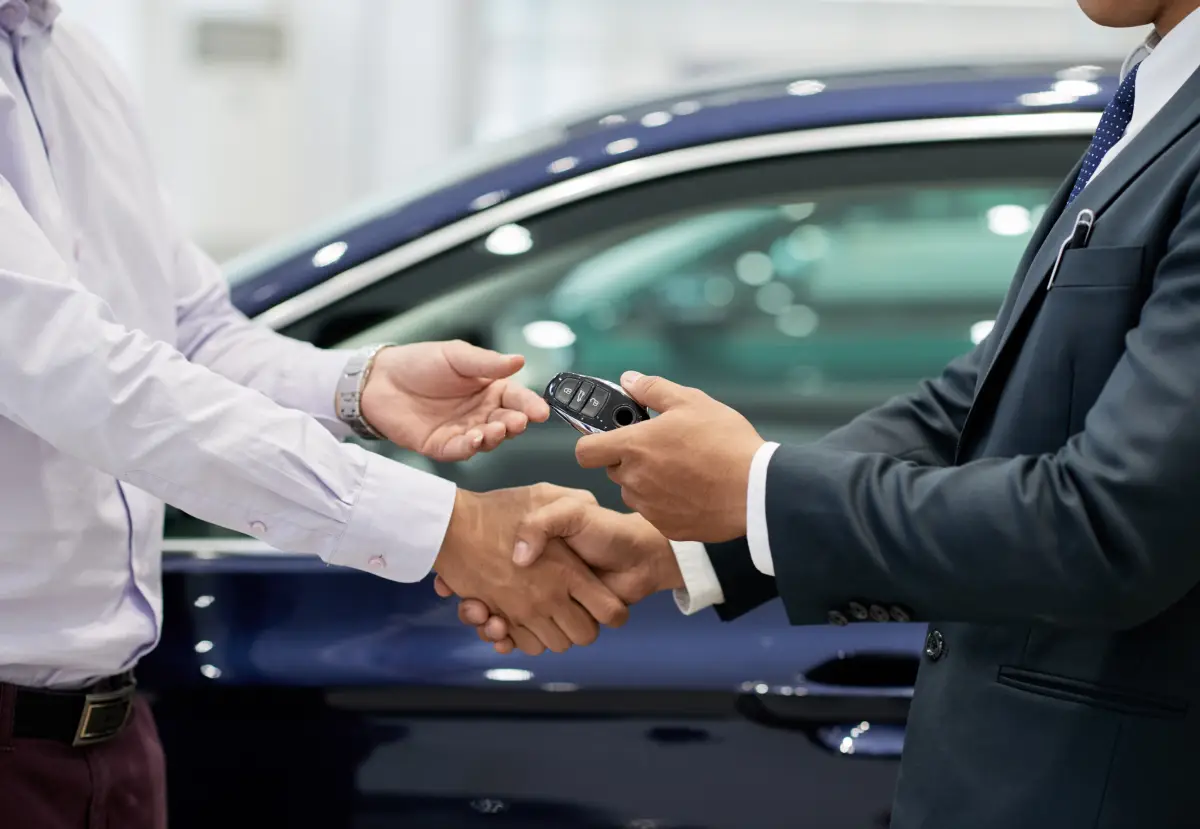 Customer receiving vehicle keys from a dealership representative