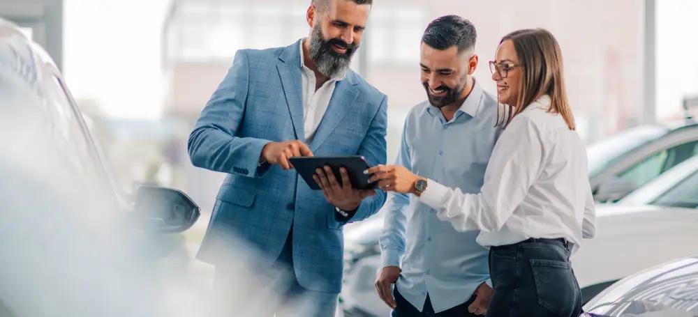 Customers reviewing vehicle financing options with dealership staff
