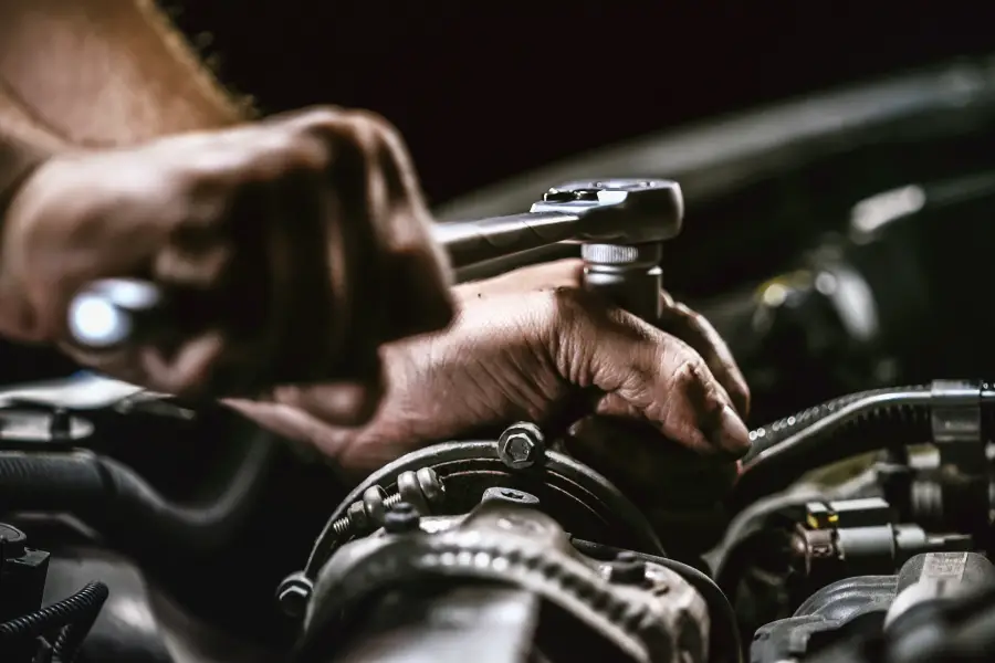 Mechanic tightening an engine bolt with a ratchet wrench