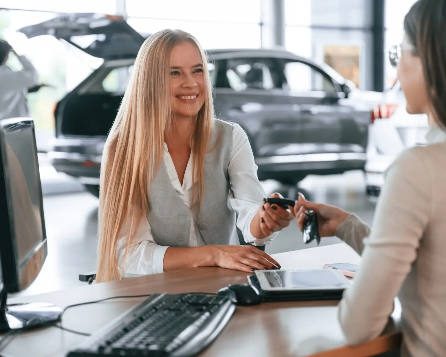 man and woman at a car dealership discussing car financing