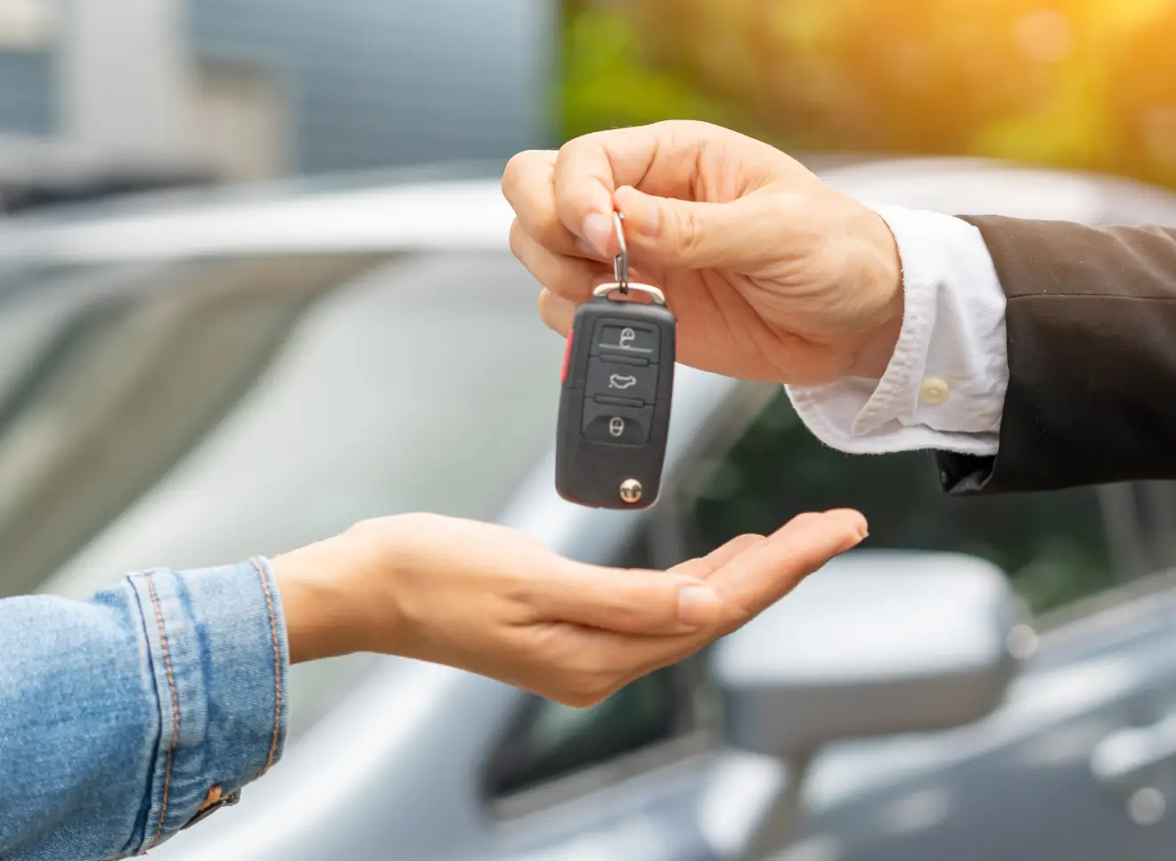 Car keys being handed to customer during purchase.