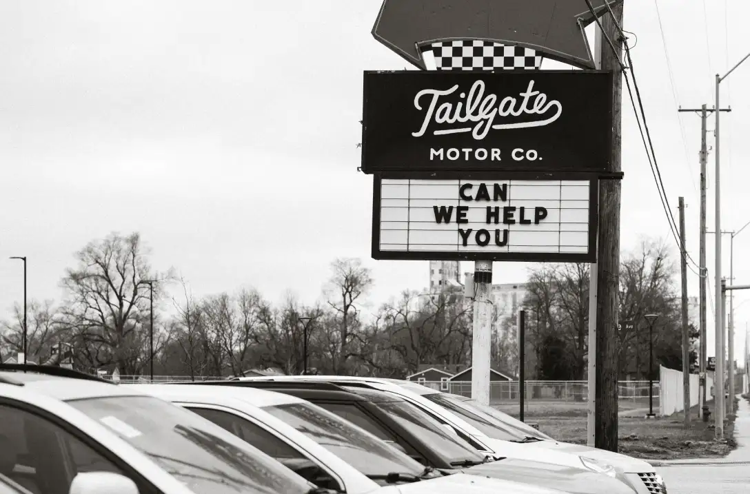 Tailgate Motor Co. roadside sign above vehicles on the lot