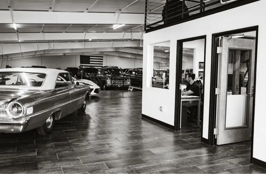 Tailgate Motor Co. showroom with classic cars, trucks, and office space