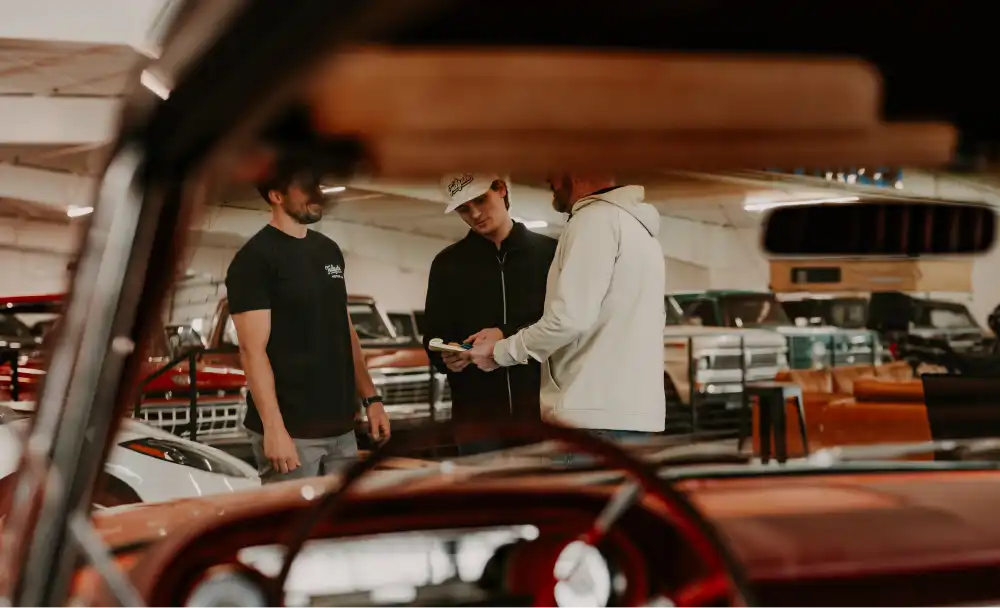 Tailgate Motor Co. team discussing vehicle details inside the showroom