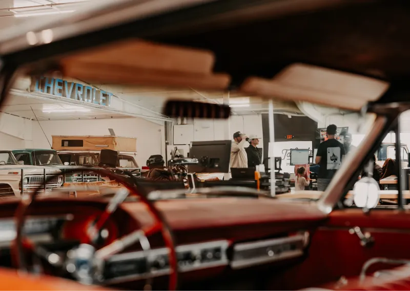 Tailgate Motor Co. showroom interior with classic vehicles and warm lighting