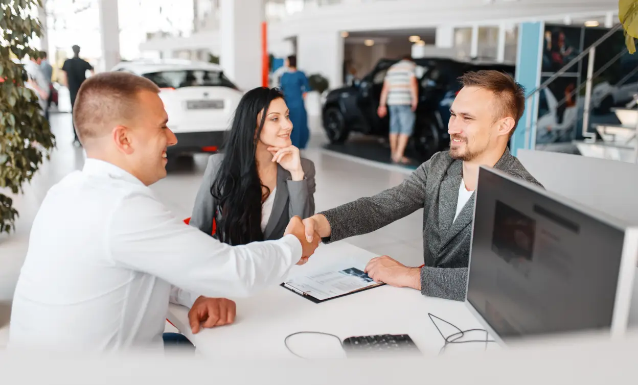 Car salesman shaking hands with a customer