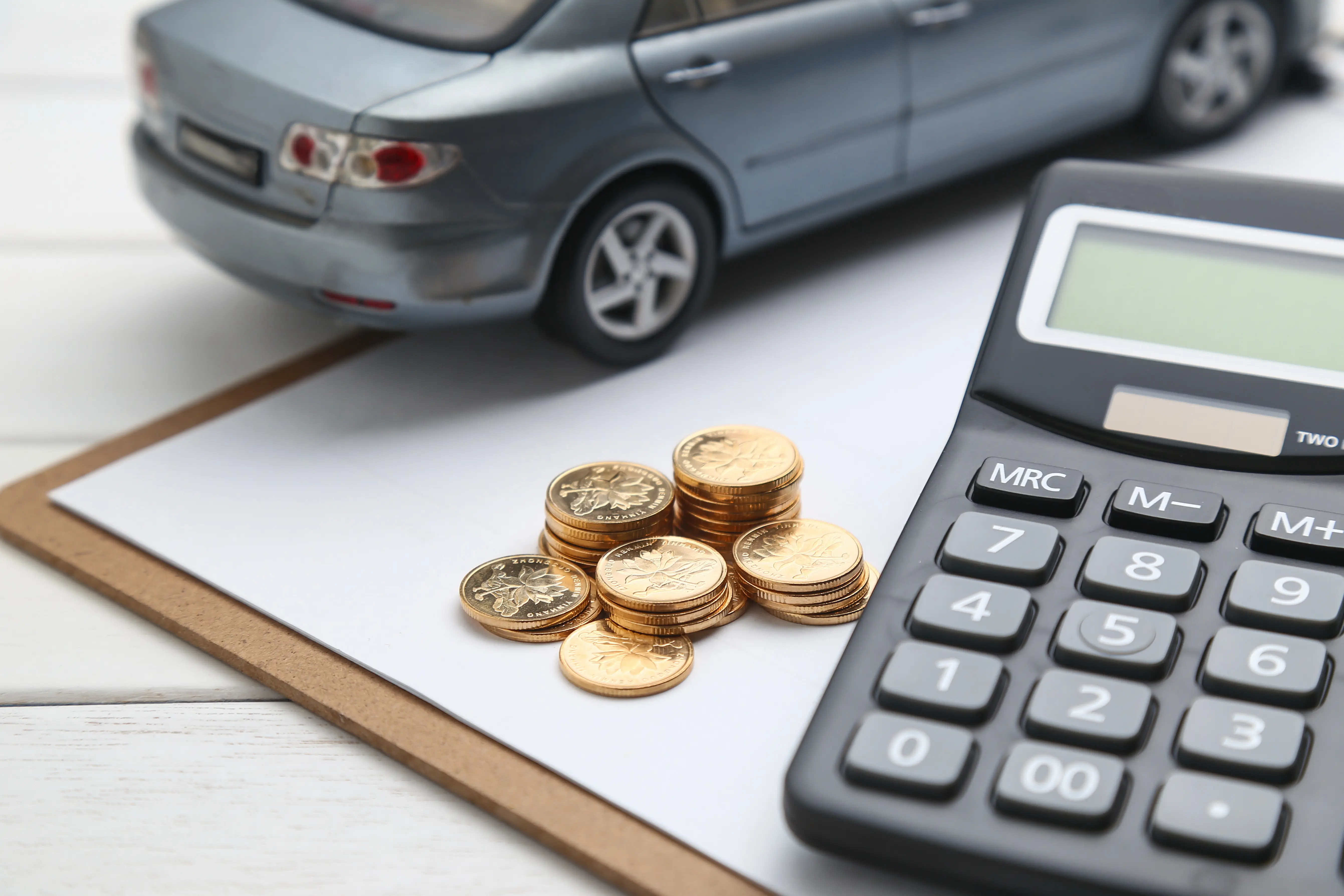 car model calculator coins white table.