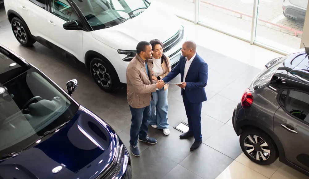 Pareja recibiendo ayuda para elegir un vehículo usado en Ultimate Autos