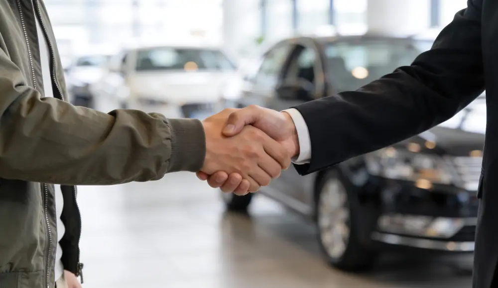 Cliente estrechando la mano de un asesor en Ultimate Autos en Mesa, AZ