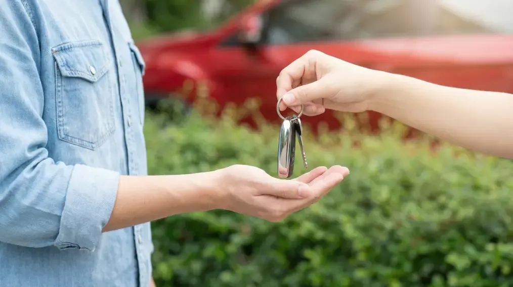 Car key being handed to a customer during vehicle delivery