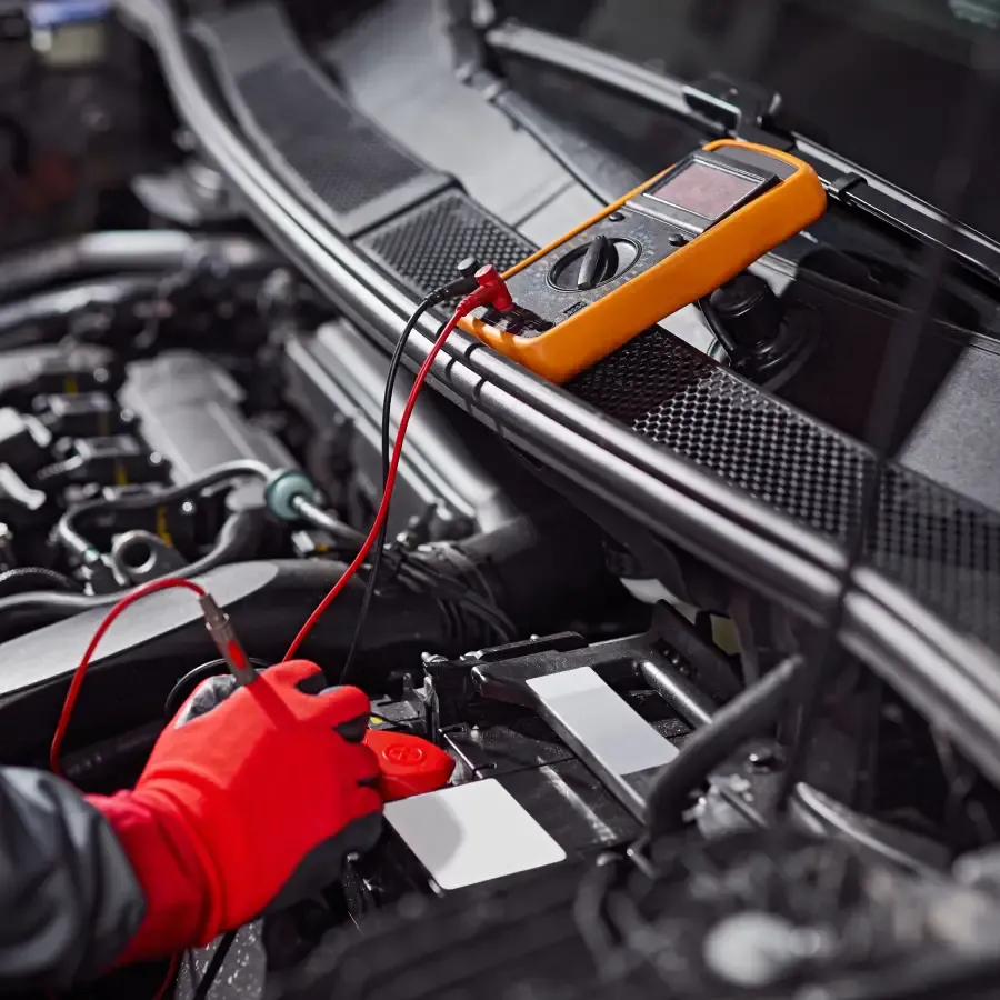 Technician testing a car battery and electrical system at Ultimate Powersports.