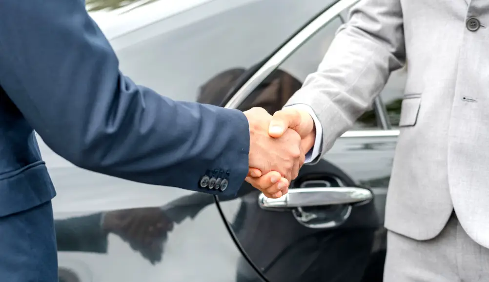 Customer shaking hands after exploring a luxury used vehicle at Ultimate Powersports