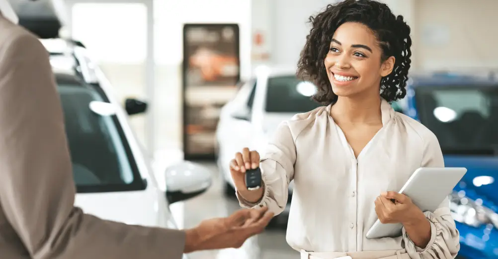 Customer receiving vehicle keys during a dealership pickup appointment