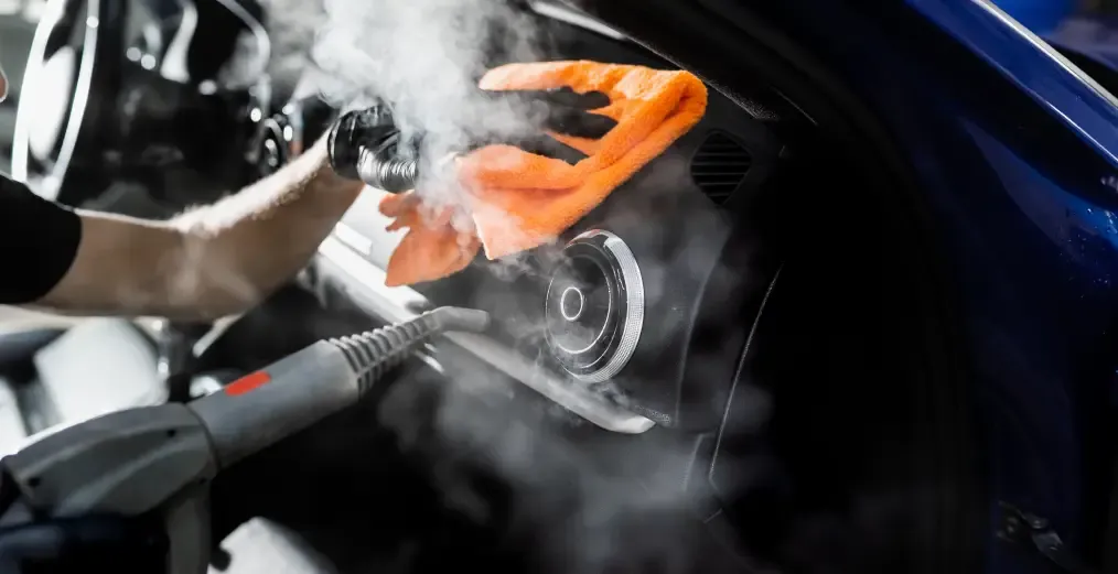 Vehicle interior being steam cleaned during a professional detailing service