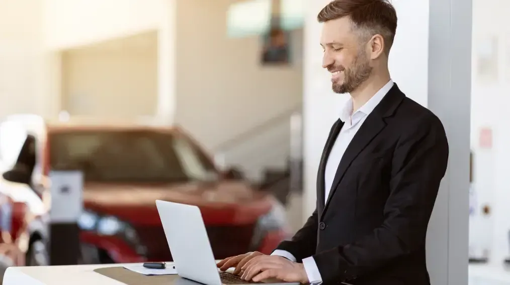 Customer browsing vehicles online from a laptop at a dealership