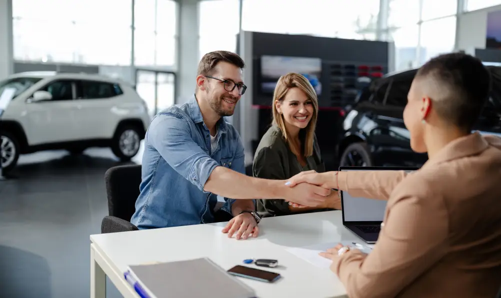 Couple completing a powersports purchase with a dealership team member