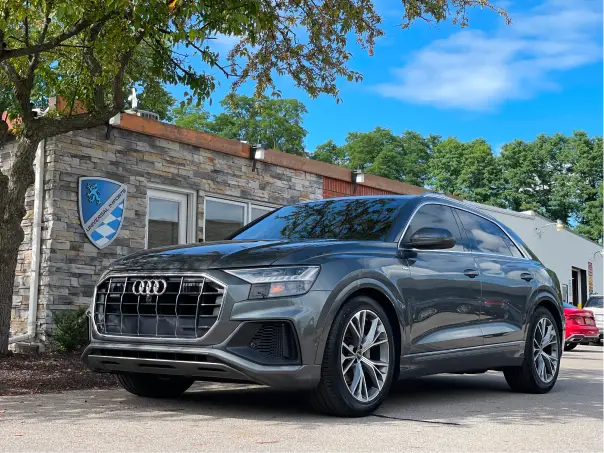 Gray Audi SUV parked outside Universal Imports building.