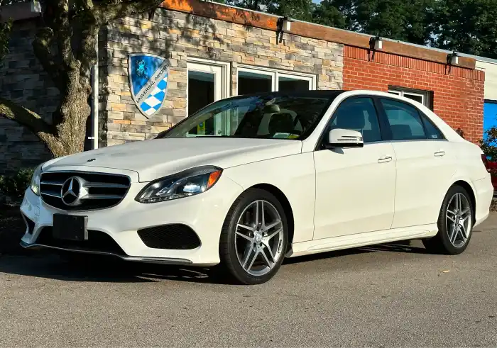 White Mercedes-Benz sedan parked outside dealership building