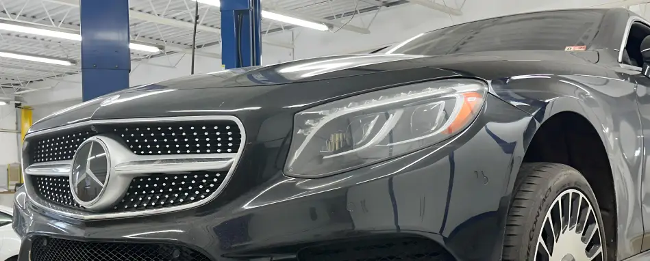 Mercedes-Benz front grille and headlight inside auto service shop