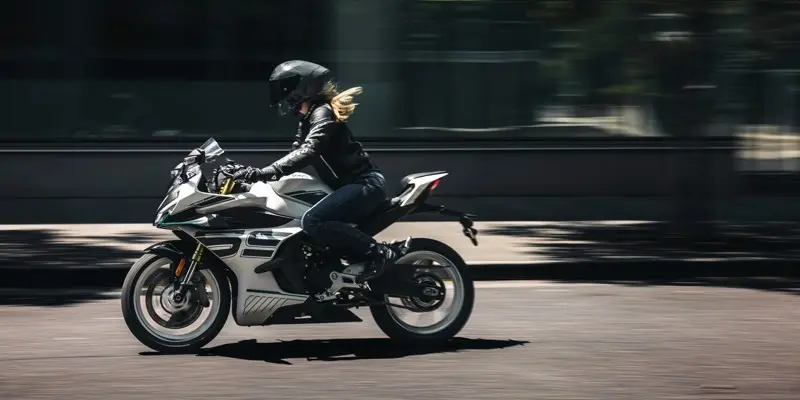 woman riding a grey and white 2026 cfmoto 450ss