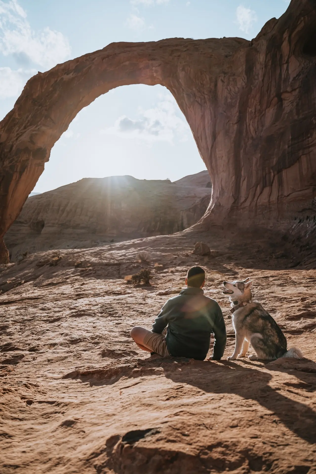 Man and Dog in Front of Scenic Arch