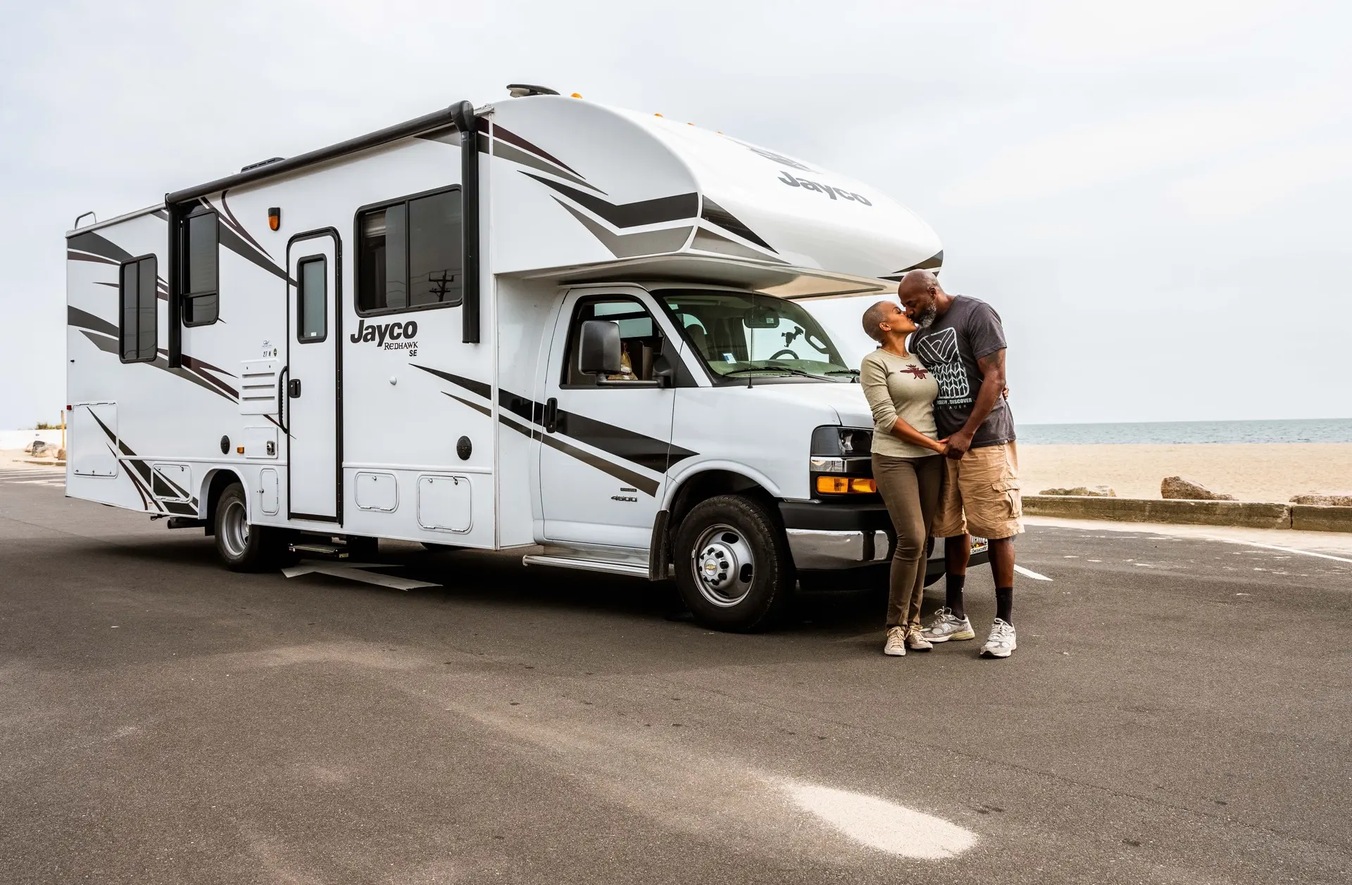Couple Kissing In Front of RV at the Beach