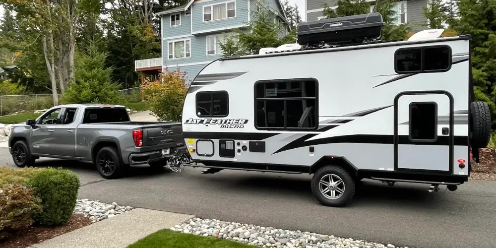 Technician changing a tire on an RV using a jack.